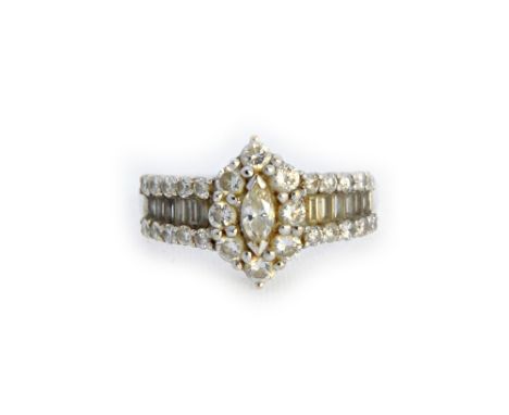 A diamond ring, the centre mounted with a marquise shaped diamond, in a surround of eight circular cut diamonds, the shoulder