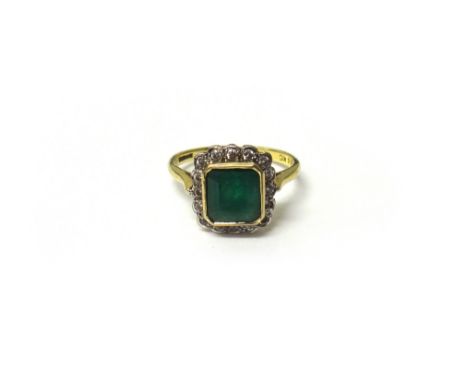 An 18ct gold, emerald and diamond square cluster ring, mounted with the cut cornered square cut emerald within a surround of 