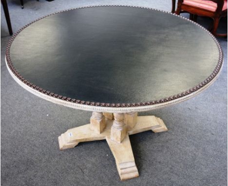 A circular centre table, with studded leather top, on bleached oak barleytwist base, 117cm wide x 75cm high.