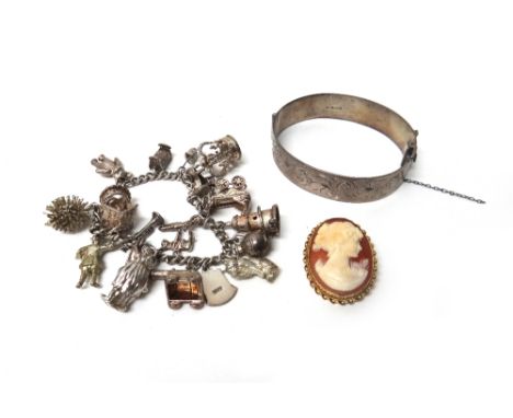 A silver curb link charm bracelet, fitted with a variety of mostly silver charms, a silver oval hinged bangle, with engraved 