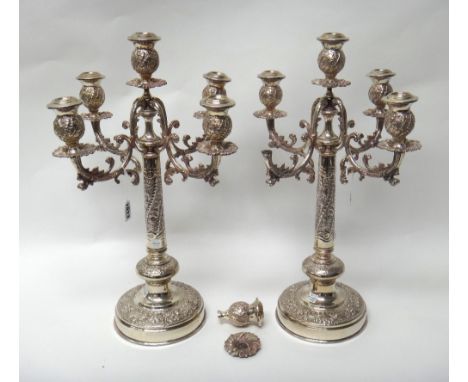 A pair of plated five light table candelabra, having scrolling arms, the columns decorated with floral and foliate sprays and