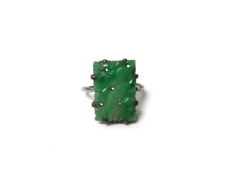 A carved jade ring, in a rectangular design, carved and pierced with fruit, (the shank somewhat distorted), with a case.