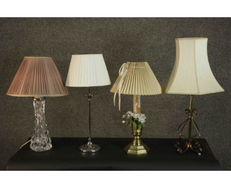 A collection of four table lamps with shades, including one formed from a brass candlestick, a wrought example, a chrome lamp