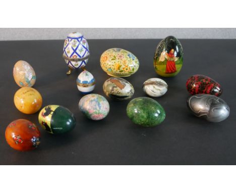 A collection of fourteen eggs, including a ceramic box, hand painted wooden eggs, a Russian painted egg, dyed marble and blow