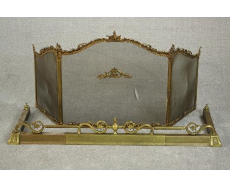 A Victorian Rococo Revival brass fireguard, the serpentine top cast with scrolling rocaille designs over a mesh body, togethe