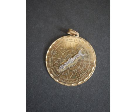 A 9ct yellow gold zodiac wheel pendant with spinning arrow and engraved lettering and symbols. London hallmarks. Weight 8.13g