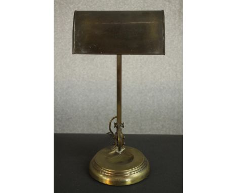 An Edwardian brass banker's desk lamp, with an adjustable shade and a circular step down base. H.43 W.21 D.16cm. 