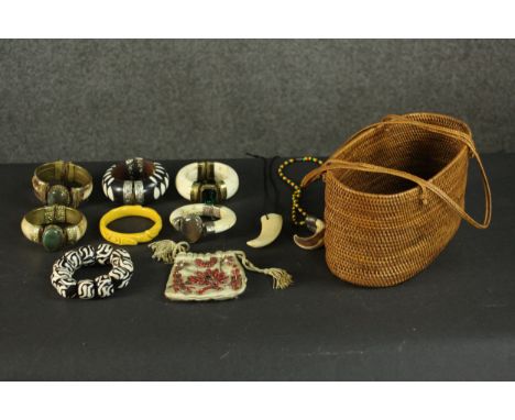 A collection of tribal jewellery including three bone and agate bangles, a carved bakelite rose design bangle, a beaded purse