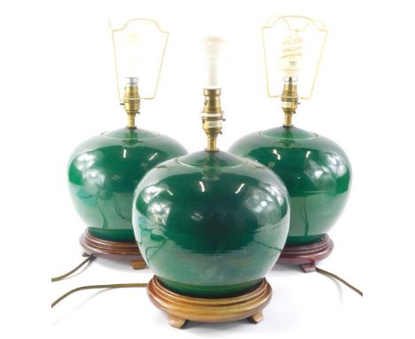 Three Chinese style green crackle glaze lamp bases, each of bulbous form on wooden bases with electrical fittings, 22cm high 