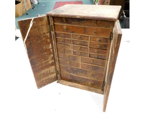 A late 19thC pine tool cabinet, set with an arrangement of drawers, containing various watch bits, spring balances, pocket li