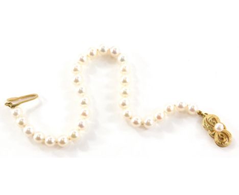 A Mikimoto pearl bracelet, with cream Gloucester pearls each approximately 4mm, on a yellow metal bow clasp set with single p