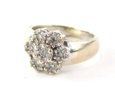A diamond cluster ring, with six petal flower design, each set with seven round brilliant cut tiny diamonds in claw setting o