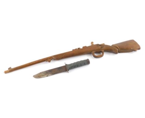 A wooden childs model of a rifle, with shaped and partially carved body, 67cm wide, and a hunting dagger, with plain blade an