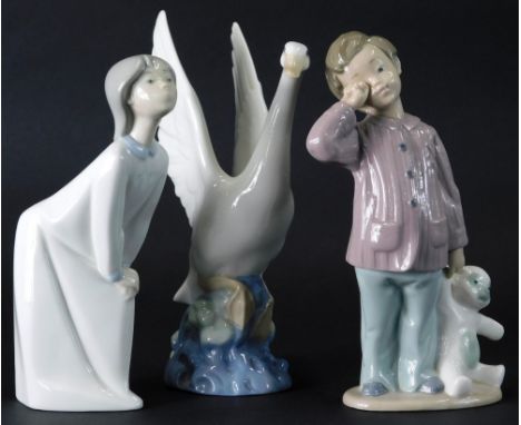 A Lladro figure of a girl bowing, printed marks beneath, 20cm high, and a Nao figure of goose with wings outstretched and a c