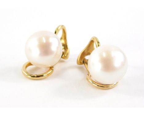 A pair of pearl earrings, each with a cream lustre finish approximately 1cm wide, on a yellow gold clip on back, stamped 375,