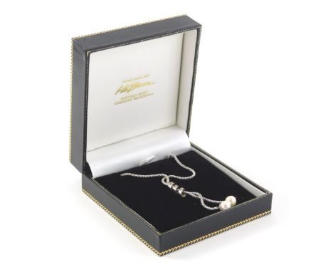 An 18ct white gold necklace, the two row twist design set with tiny diamonds, with two natural pearl drops, on an interlinked