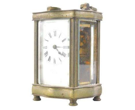 An early 20thC brass carriage clock, in a five part glazed serpentine case with 5cm back plate Roman numeric dial and compres