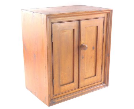 An early 20thC pine hanging cupboard, with panelled doors, and a shelf, 53cm high, 45cm wide, 29cm deep.