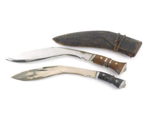 An early 20thC Kukri, with scabbard and turned handle inset with metal mounts, 43cm wide, a further Kukri and a small Eastern