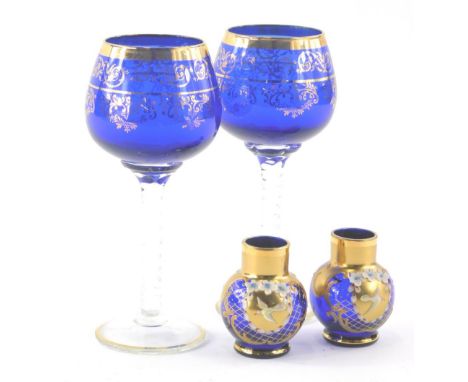 A pair of Bohemian blue glass wine goblets, with turned stems and gilt highlights, 18cm high and a further pair of blue glass