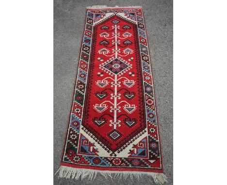 Turkish runner, the pole medallion on a red serrated field within a blue green and red border, 208 x 77 cm 
