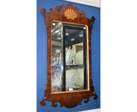 A 'George III' mahogany Vauxhall looking glass, rectangular mirror plate trimmed in giltwood, crested by an incise carved sun