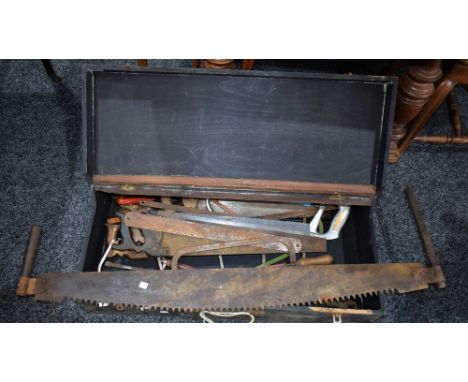 Tools - a large wooden tool box containing assorted hand saws, large twin handled saw, coping saws, etc