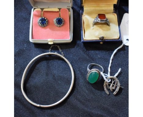 An Arts and Crafts carnelian set ring; a silver bangle; a silver brooch; a carnelian set silver dress ring