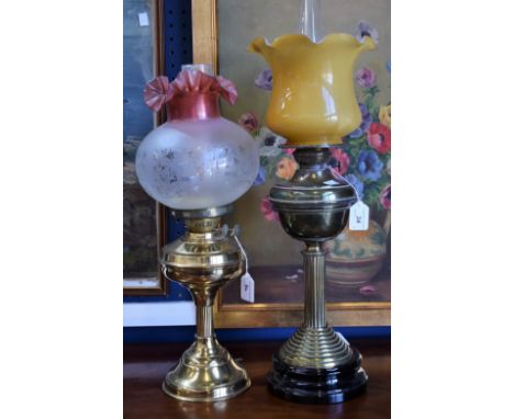A late 19th/early 20th century oil lamp, brass column and reservoir, opaque glass shade; another, later electric lamp (2)