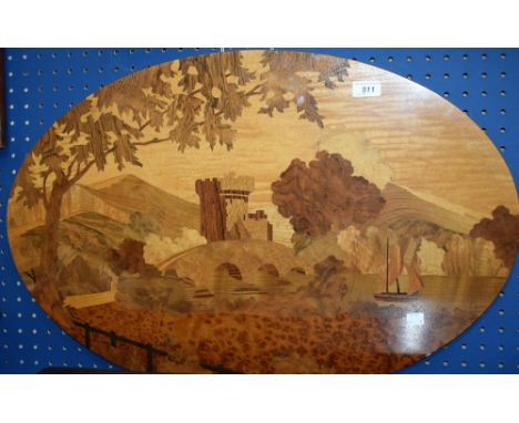 An oval marquetry panel depicting a waterside castle, approx 75cm x 50cm