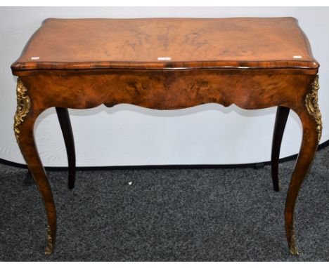 A Victorian gilt metal mounted walnut serpentine card table, hinged top enclosing a baize lined playing surface, tapered serp