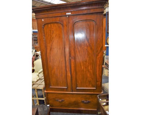 A Victorian mahogany wardrobe, rounded cornice above a pair of panel doors and a single long drawer, plinth base, 208cm high