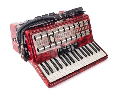 A Bandmaster red marbled piano accordion in case. 