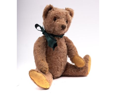 A mid 20th century brown mohair growler teddy bear probably Steiff, button missing, plastic eyes, 34cm long.
