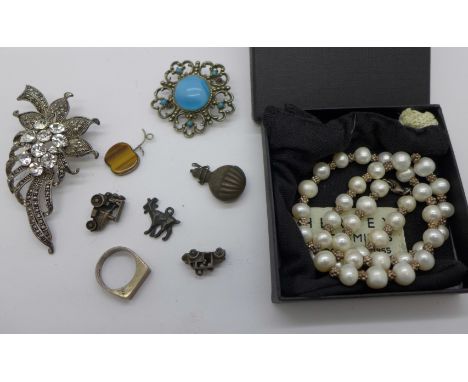 A silver and tigers eye ring and apple pendant, two brooches, a silver mounted pearl necklace and silver charms 