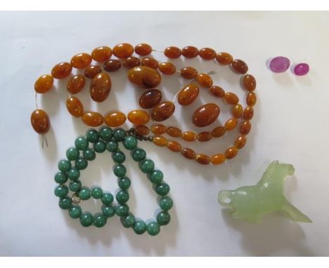 A green Jade/Jadeite necklace, a Jadeite horse, a broken amber type necklace and two ruby colour stones 