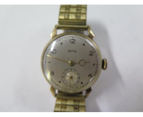 A 9ct yellow gold Smiths manual wind gents presentation wristwatch on a sprung plated strap - 30mm case - running, hands adju