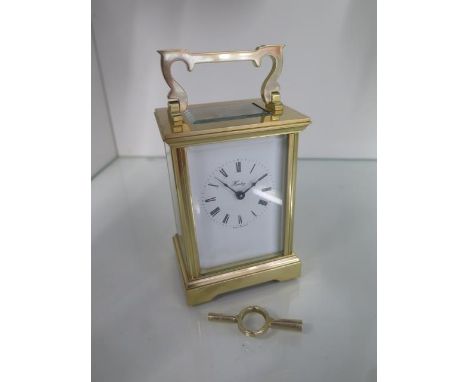 A brass carriage clock the dial signed Henley - Height 15cm with handle up - in good condition, working order with key 