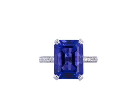 A FINE TANZANITE AND DIAMOND RINGThe rectangular step-cut tanzanite weighing 10.08cts within a four-claw setting, between a l