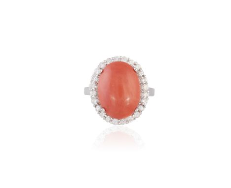 A CORAL AND DIAMOND CLUSTER RINGThe oval-shaped cabochon coral corallium rubrum, within a frame of round brilliant-cut diamon