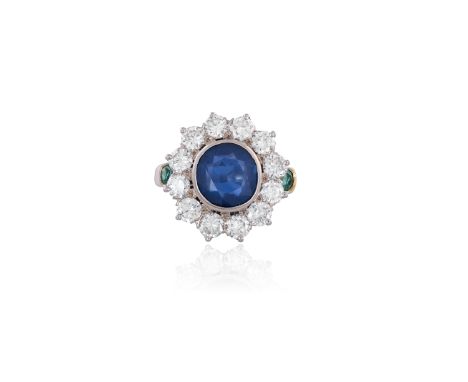 A SAPPHIRE, DIAMOND AND EMERALD CLUSTER RINGThe round brilliant-cut sapphire in collet-setting, within a surround of round br