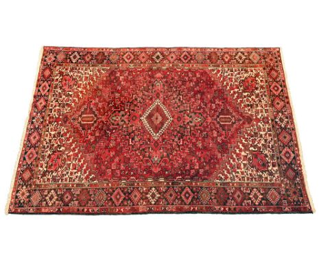 A vintage Persian rug, with red ground and repeating geometric patterns. 346 x 255 cm (see illustration).