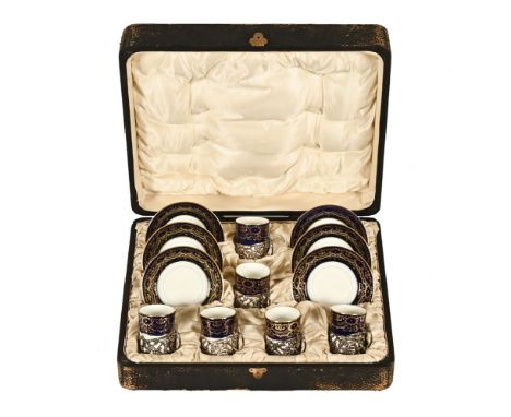 A Cauldon cased coffee set, with blue white and gilt decoration, the cups with hallmarked silver base and handles. London 191