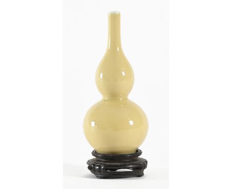 A Chinese double gourd porcelain glazed vase, with concentric Kangxi blue rings to the base and with wooden stand. Vase heigh