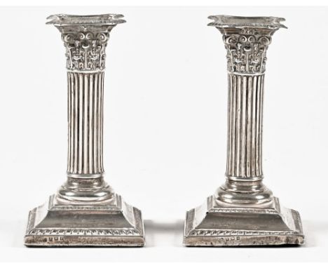 A pair of silver Corinthian column candlesticks, with square bases, Birmingham 1913.  Height 14.5 cm.
