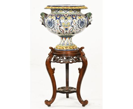 A large Italian Majolica jardiniere, with mask handles to either side and raised on an oriental wooden jardiniere stand. Over