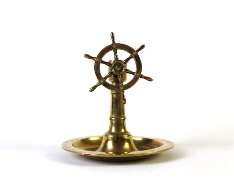 An antique brass ships wheel cigar cutter, match striker and ashtray combination.