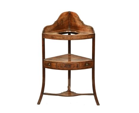 A late Georgian mahogany corner washstand, with basin aperture and fitted with a single drawer to the middle section and with