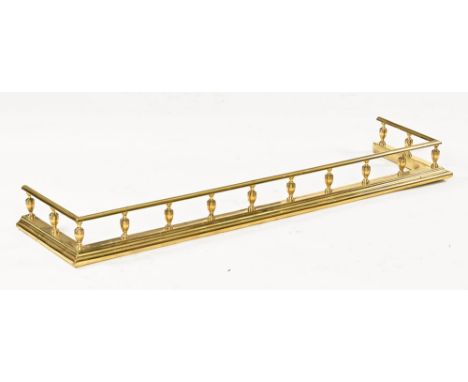 An Edwardian brass fender, with spindled gallery and moulded base.  Internal width 131 cm, return 30 cm.