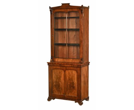 A small Regency mahogany bookcase, with architectural pediment above a glazed door opening to adjustable shelves, the base wi